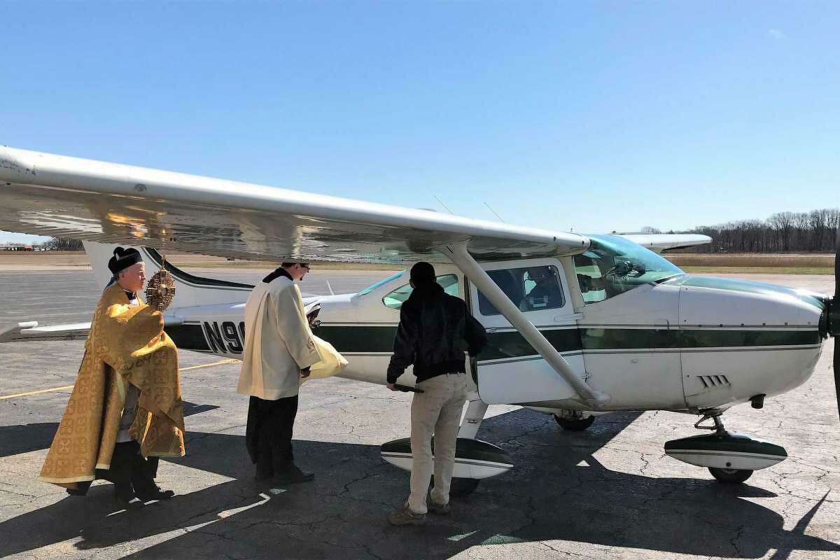 The Rev. Brian Gannon of St. Theresa Roman Catholic Church in Trumbull and the Rev. Flavian Bejan, associate pastor, prepare to board a Cessna 172 plane at Sikorsky Memorial Airport before flying over the Bridgeport Diocese to bestow blessings March 24, 2020.