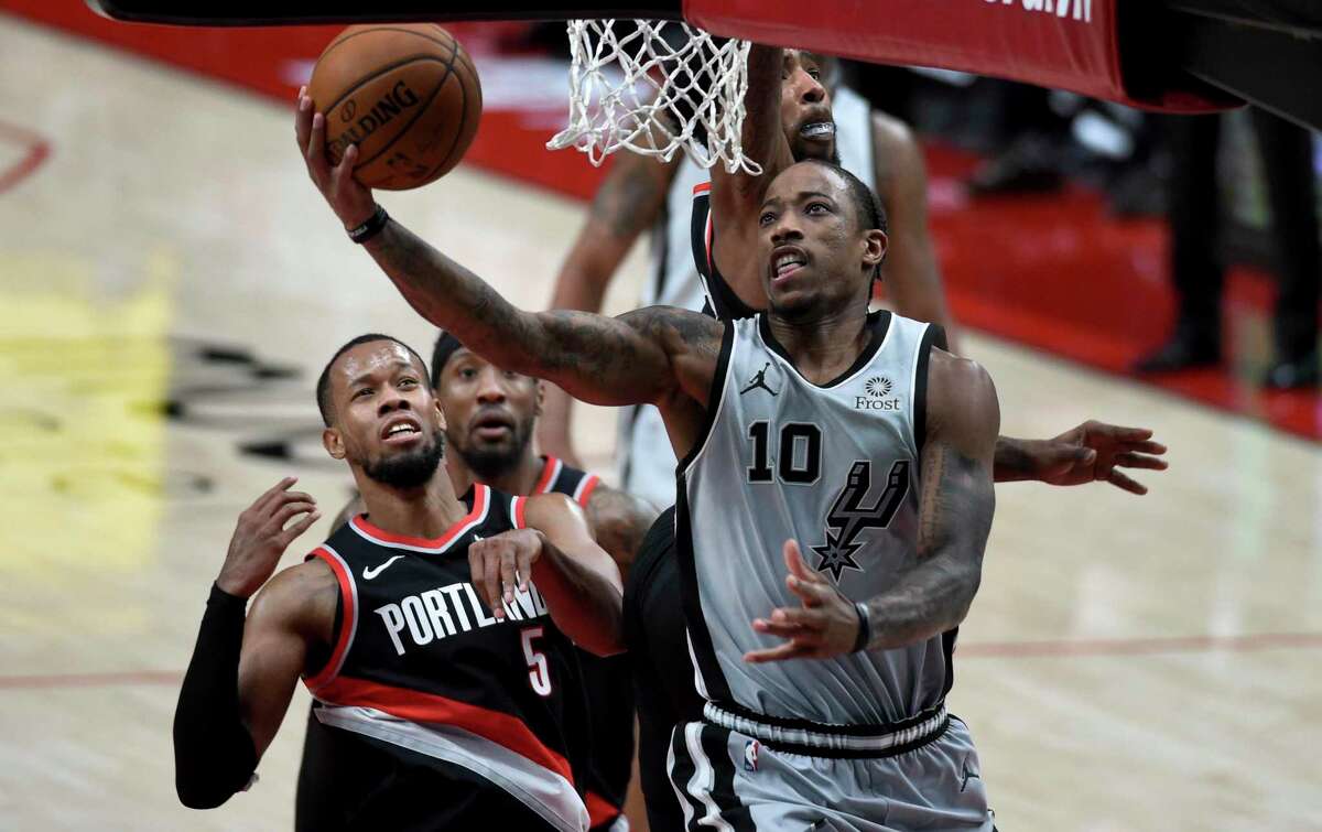 San Antonio Spurs forward DeMar DeRozan, right, drives to the basket on Portland Trail Blazers guard Rodney Hood, right, during the second half of an NBA basketball game in Portland, Ore., Monday, Jan. 18, 2021. (AP Photo/Steve Dykes)