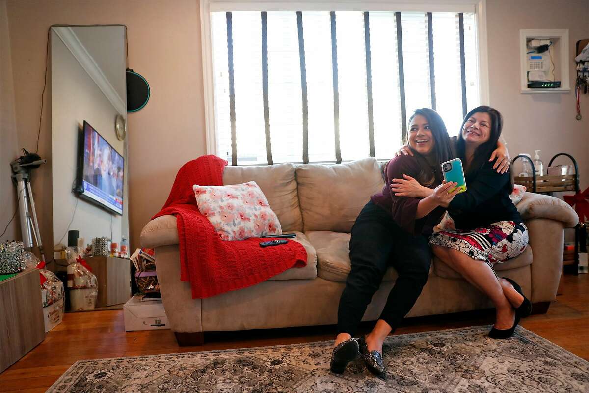 DACA recipient Vanessa Mejia and her mother, Conie, watch from their living room in Oakland, Calif., as US President Joe Biden takes the oath of office at the US Capitol in Washington, DC on Wednesday, January 20, 2021.