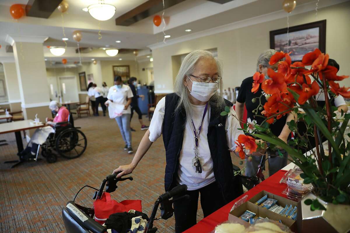 Virginia Quong, 77, admires the tables set up with food and snacks for available for residents after they received Pfizer COVID-19 vaccinations at a vaccine clinic at the senior living community in Daly City. CVS administered the vaccine clinic.