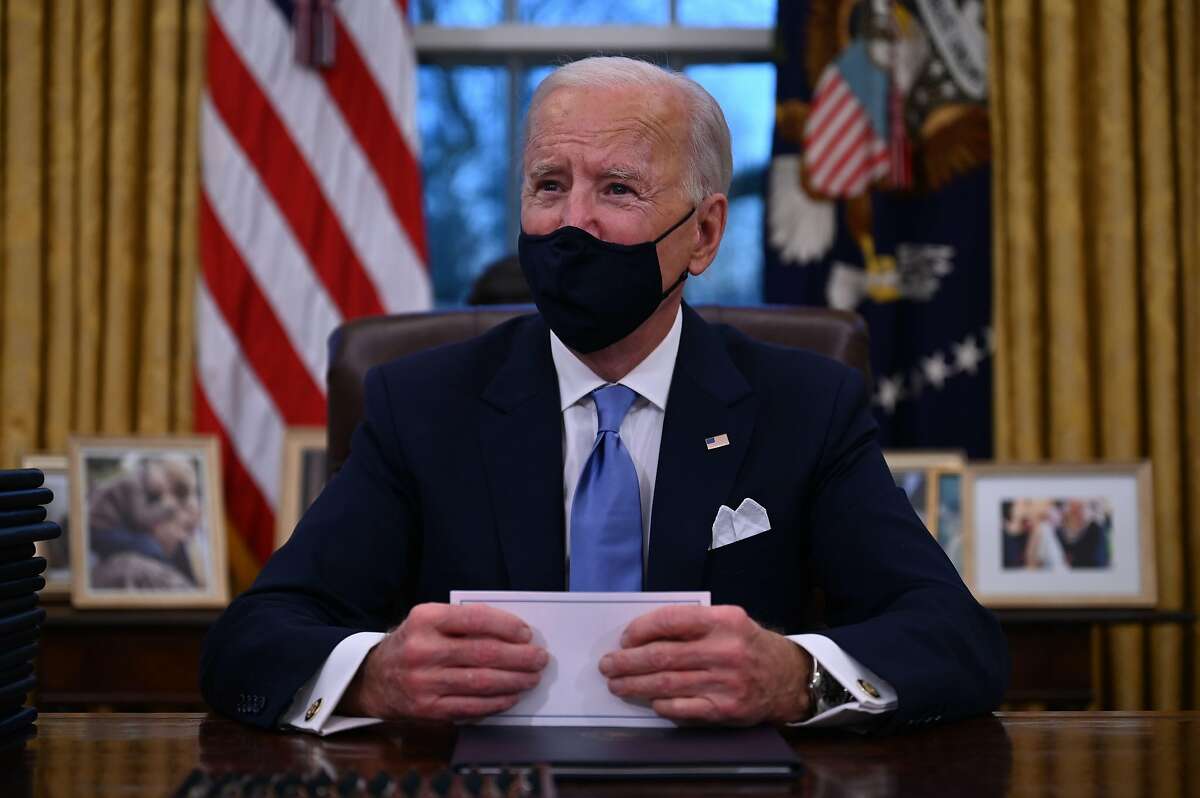 US President Joe Biden prepares to sign a series of orders in the Oval Office of the White House in Washington, DC, after being sworn in at the US Capitol on January 20, 2021. (Photo by Jim WATSON / AFP) (Photo by JIM WATSON/AFP via Getty Images)