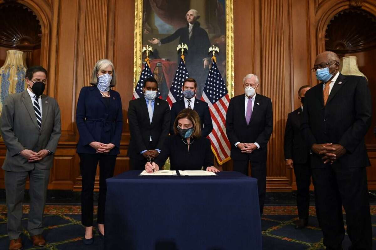 Speaker of the House Nancy Pelosi (D-CA) (C), signs the article of impeachment, alongside impeachmentmanagers, during an engrossment ceremony after the US House of Representatives voted to impeach the US President Donald Trump at the US Capitol, January 13, 2021, in Washington, DC.