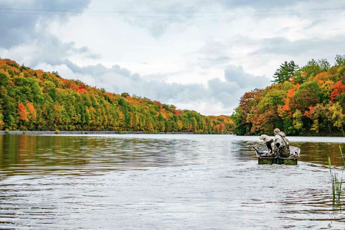 A goose hunter and his dog get ready to head out on the waters of Goose Lake in Marquette County.