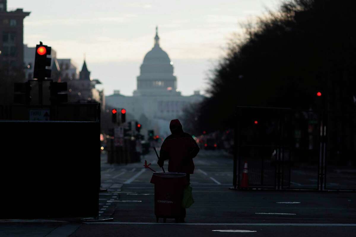 A cleaner works on a street near the Capitol on Thursday as streets reopen one day after the inauguration of President Joe Biden.