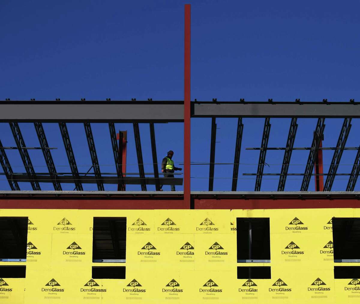A crew continues construction on a new apartment building near St. Andrews Episcopal Church on Washington Boulevard in Stamford, Conn. Wednesday, Jan. 20, 2021.