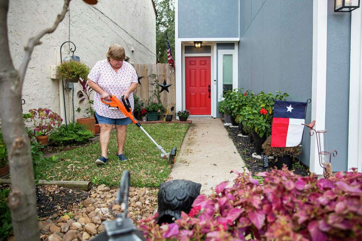 Suzanne Slavinsky works on her yard near the Watson Grinding & Manufacturing facility. Slavinsky and roommate Alicia Detamore were able to move back into their home in June, a few months after they watched their roof collapse as workers tried to repair it.