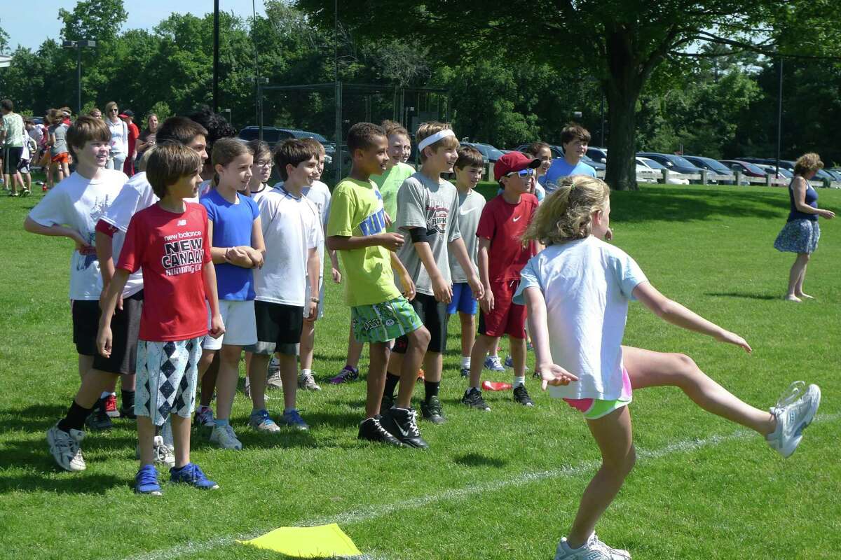 Saxe fifth-graders watch a participant playing a game during field day Friday, June 1, at Saxe Middle School in New Canaan, Conn.