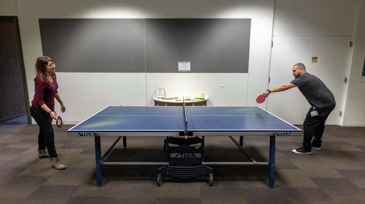 USAA employees play table tennis Wednesday, Feb. 26, 2020 in one of the company's Energize areas. The break areas are one of the many on-site perks the Fortune 500 company offers to employees. Chick-fil-A, a medical clinic, a fitness center and food court-style dining are among the other offerings in the company's headquarters.