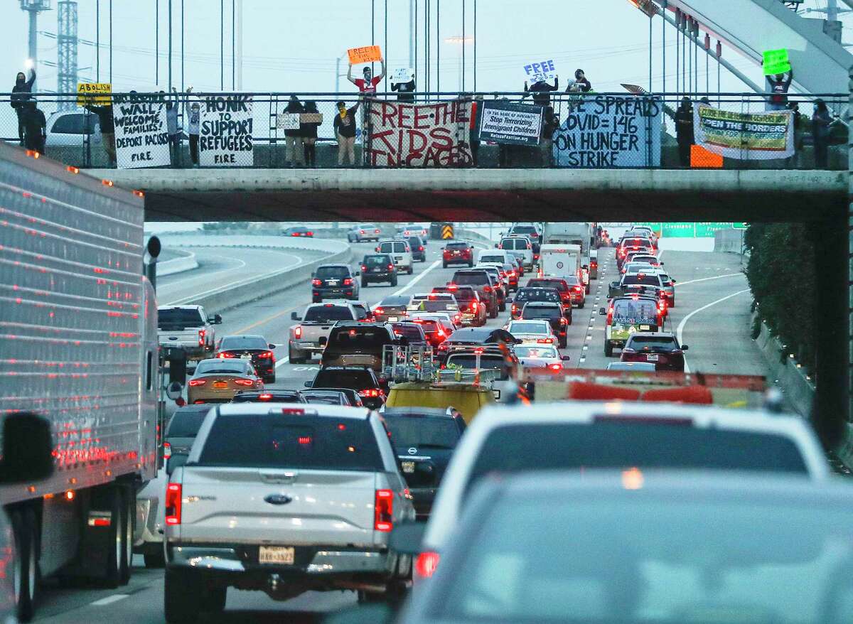 As members of the group Brown Berets dropped a banner from the Montrose Bridge over highway 59, in Houston, Wednesday, Jan. 20, 2021. After meeting up in Emancipation Park, the group caravanned to the Montrose bridge asking for a National call to action on immigration.