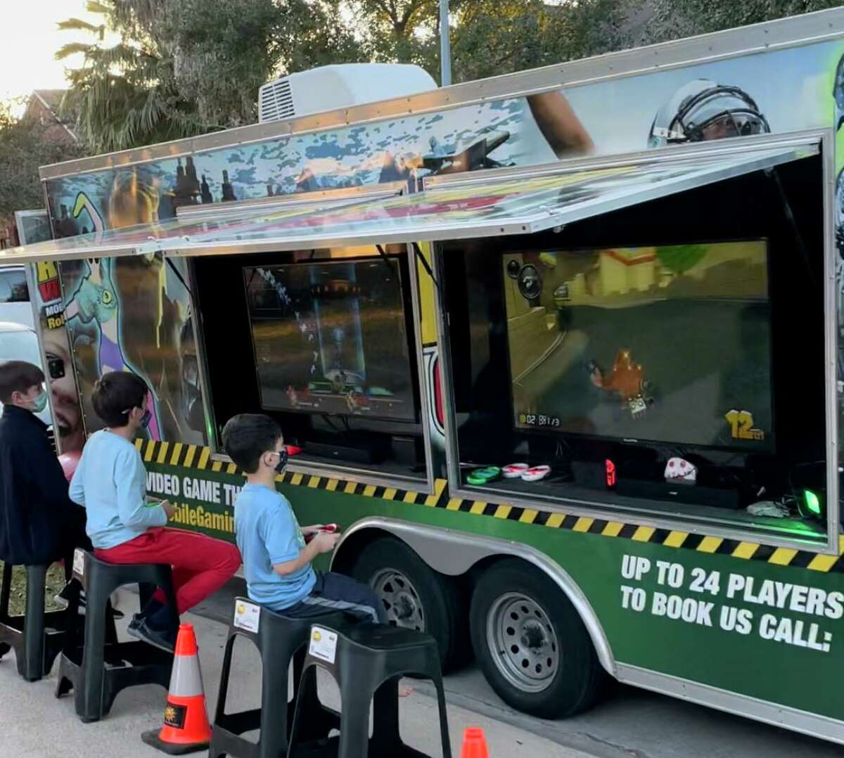 Children attending a birthday party play video games in Optimum Mobile Gaming’s video game truck on Jan. 22, 2021.