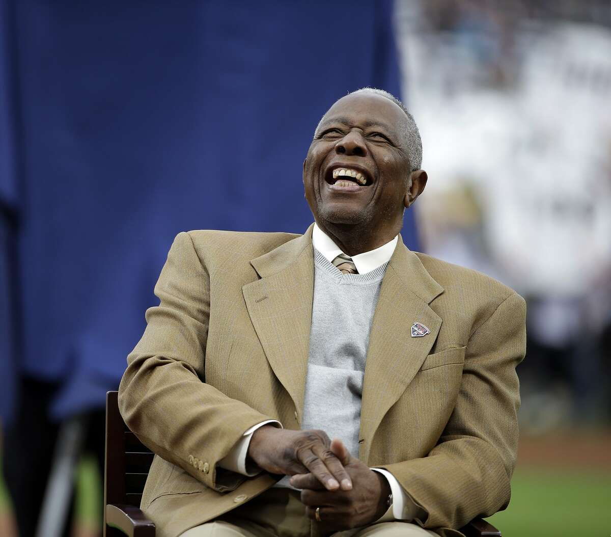 FILE- In this April 8, 2014, file photo, Hank Aaron laughs during a ceremony celebrating the 40th anniversary of his 715th home run before the start of a baseball game between the Atlanta Braves and the New York Mets in Atlanta. Hank Aaron, who endured racist threats with stoic dignity during his pursuit of Babe Ruth but went on to break the career home run record in the pre-steroids era, died early Friday, Jan. 22, 2021. He was 86. The Atlanta Braves said Aaron died peacefully in his sleep. No cause of death was given. (AP Photo/David Goldman, File)