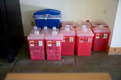 Sharps boxes full of empty syringes wait to be disposed of at the St. Helena Foundation vaccination clinic at Napa Valley College in St. Helena, Calif. on Thursday, Jan. 21, 2021. The St. Helena Hospital Foundation is working with local wineries, investors , and community health works to help distribute COVID-19 vaccines to elderly community members and local winery and agriculture workers in order to help stop the spread of the virus.