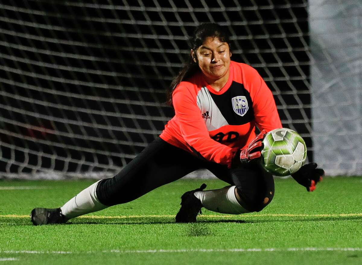 New Caney goalie Esveidy Norberto (00) makes a stop during the first period of a non-district high school soccer match at Grand Oaks High School, Friday, Jan. 22, 2021, in Spring.
