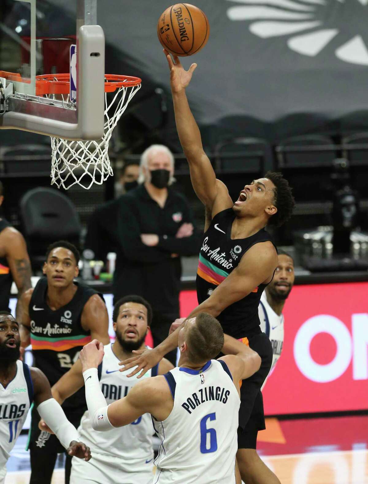 Spurs' Keldon Johnson (03) scores over Dallas Mavericks' Kristaps Porzingis (06) at the AT&T Center on Friday, Jan. 22, 2021.