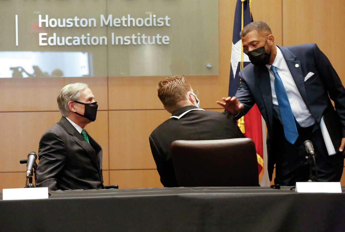 Texas State Senator Borris Miles (right) talks to Texas Governor Greg Abbott (left)) and Texas Division of Emergency Management (TDEM) Chief Nim Kidd after a COVID-19 vaccination roundtable discussion with healthcare professionals in Houston Methodist Hospital Tuesday, Jan. 19, 2021, in Houston.
