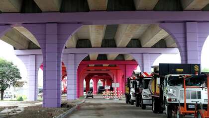 Workers place a beam on the Elysian Viaduct, with it's colorful new columns, over I-10 East Freeway, Thursday, June 25, 2020, in Houston.