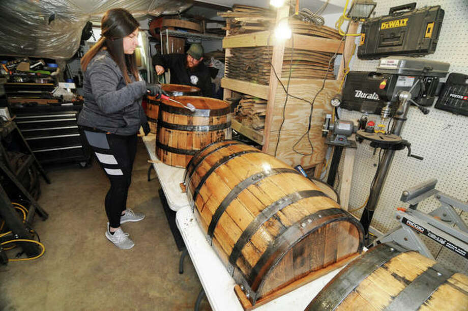 Faith and Ryan Jenkins apply finish to their creations at Second Hand Barrels in Godfrey. The business has grown so much that in March it will move into a commercial facility on Stanka Lane in Godfrey,