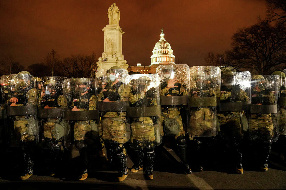 National Guard members stand outside the Capitol after a day of rioting.