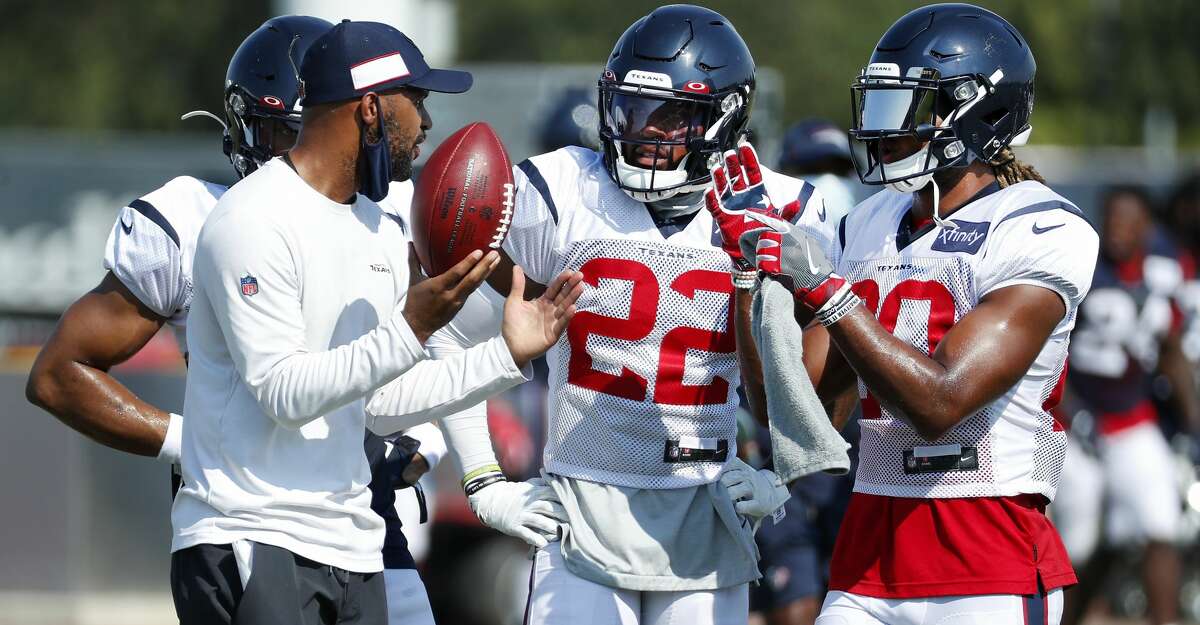Houston Texans secondary coach D'Anton Lynn works with cornerback Gareon Conley (22) and safety Justin Reid (20) during an NFL training camp football practice Sunday, Aug. 23, 2020, in Houston.