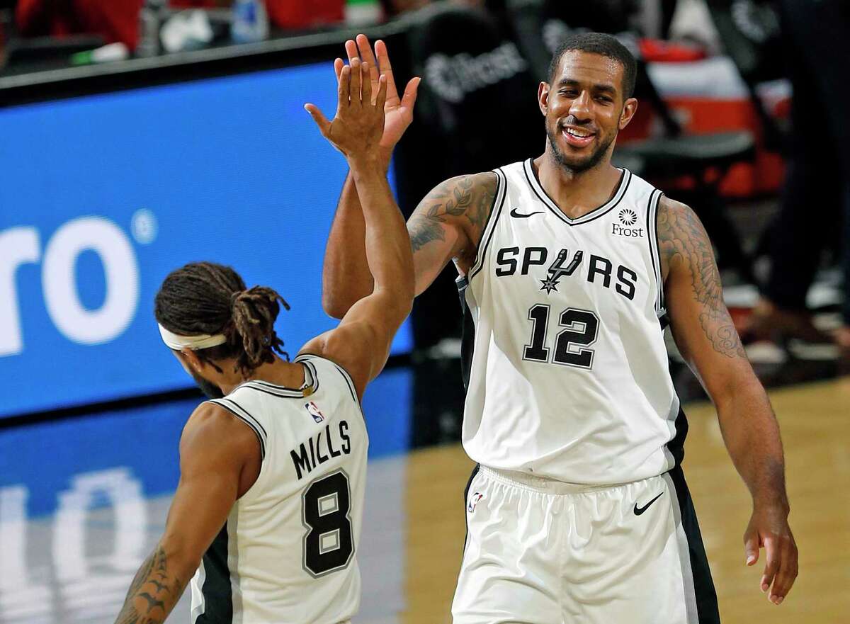 LaMarcus Aldridge #12 of the San Antonio Spurs high fives Patty Millslas Spurs defeated the Wizards 121-101. Wizards v Spurs at AT&T Center on Sunday, Jan. 24, 2021