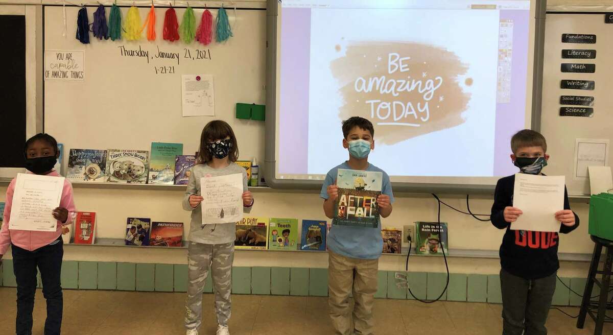 Elizabeth Shelton School first graders, left to right, Kendall Harvey, Madeline Smith, Henry Muoio and Connor Freeman show off the letters they sent to author Dan Santat. The entire class earned the chance to connect with Santat as part of winning a special contest.