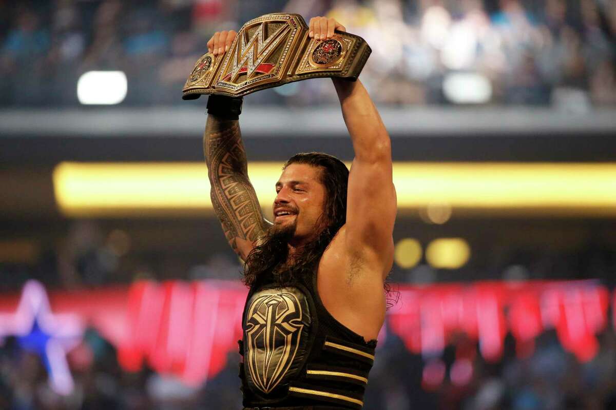 In this April 3, 2016 file photo, Roman Reigns holds up the championship belt after defeating Triple H during WrestleMania 32 at AT&T Stadium in Arlington, Texas. WrestleMania will be one of the WWE events featured on NBCUniversal’s Peacock streaming service, as part of a new agreement that will see WWE Network’s programming to Peacock.