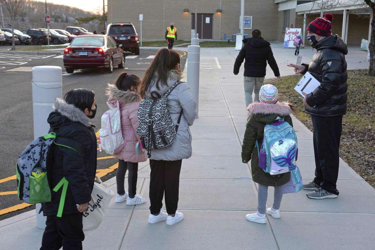 Physical Education teacher Chris Ruggiero instructs returning Stadley Rough Elementary School students where to go as they return for the first time since March of last year. Tuesday, January 19, 2021, in Danbury, Conn.