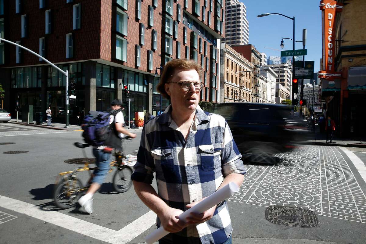 Larry Williamson, neighborhood resident, stands at the intersection of Taylor and Eddy streets as cars drive by behind him, during a tour of the Tenderloin with the Concerned Citizens for Traffic Safety Action Committee.