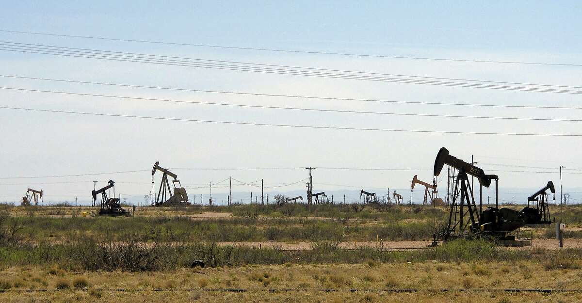 FILE - In this April 9, 2014, file photo, oil rigs stand in the Loco Hills field on U.S. Highway 82 in Eddy County near Artesia, N.M., one of the most active regions of the Permian Basin.  (AP Photo/Jeri Clausing, File)