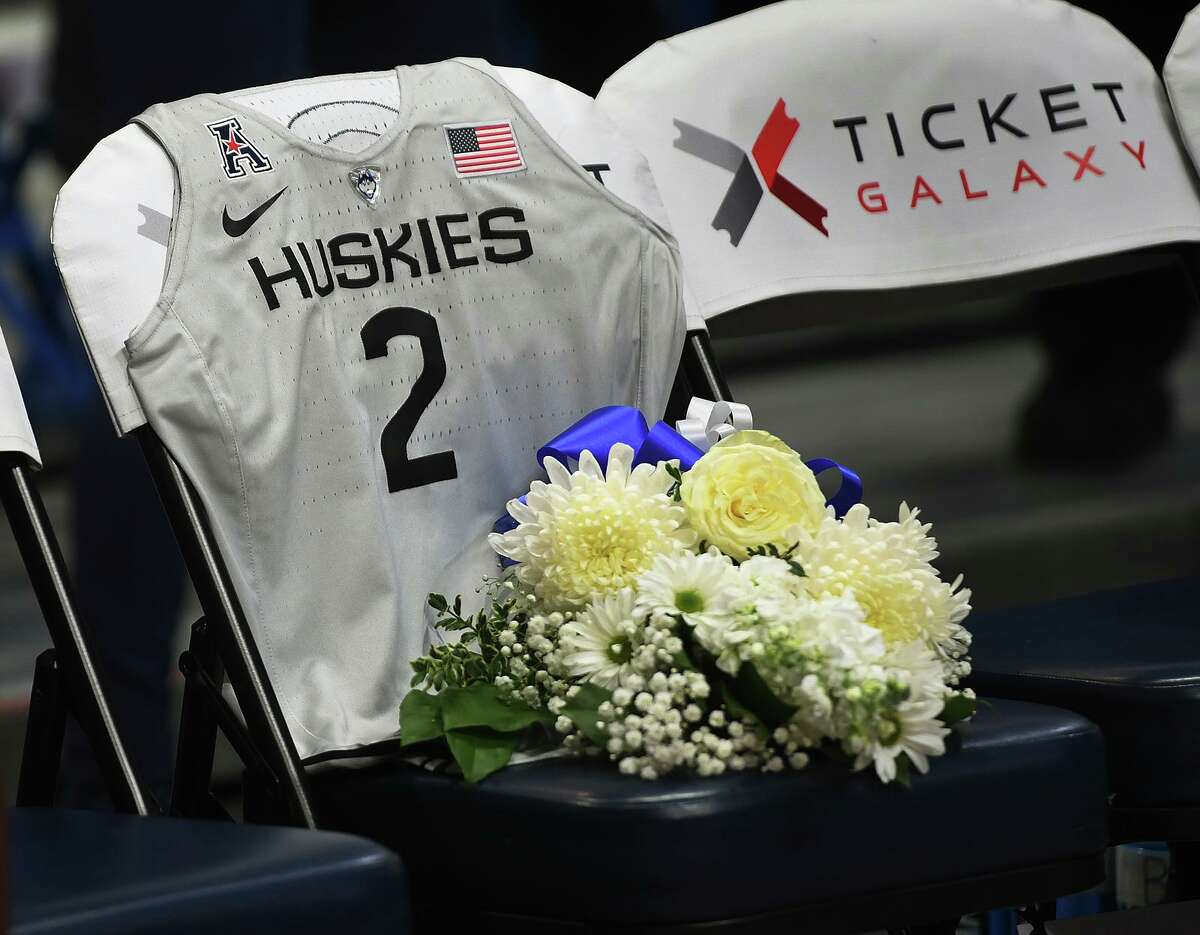 A chair on the UConn bench is covered by a small team jersey and a bouquet of flowers in honor of Gianna Bryant, daughter of Kobe Bryant, at an exhibition game between Team USA and the Huskies on Jan. 27, 2020 in Hartford.