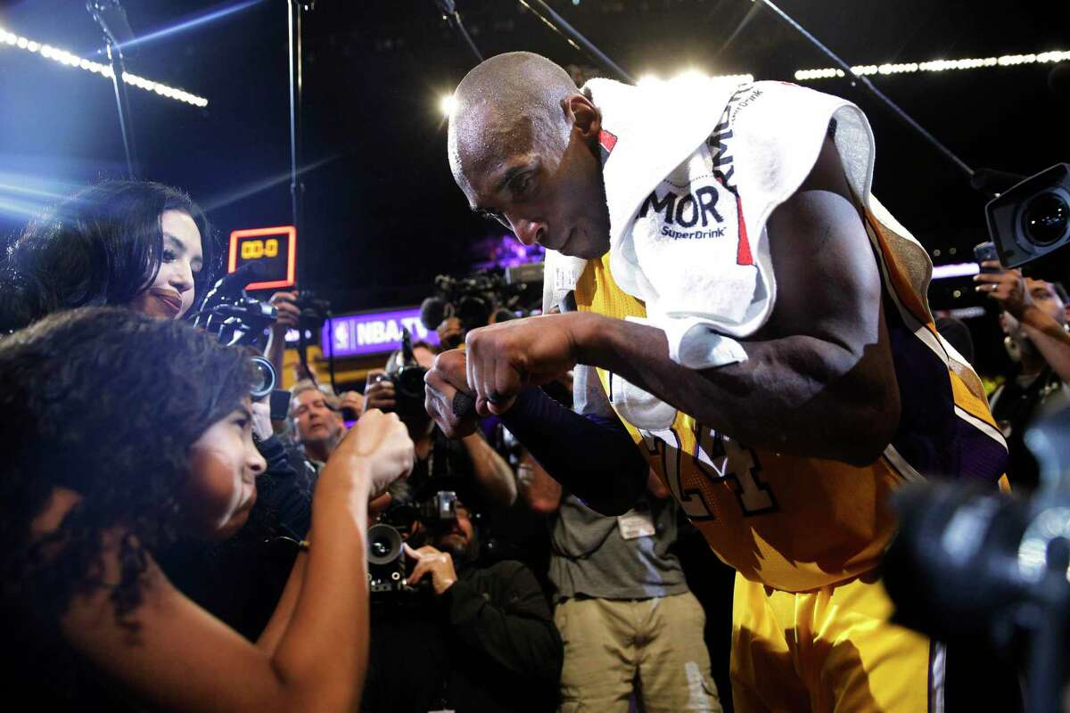 Los Angeles Lakers' Kobe Bryant, right, fist-bumps his daughter Gianna after the last NBA basketball game of his career, against the Utah Jazz on Wednesday, April 13, 2016, in Los Angeles.Bryant scored 60 points as the Lakers won 101-96. (AP Photo/Jae C. Hong)