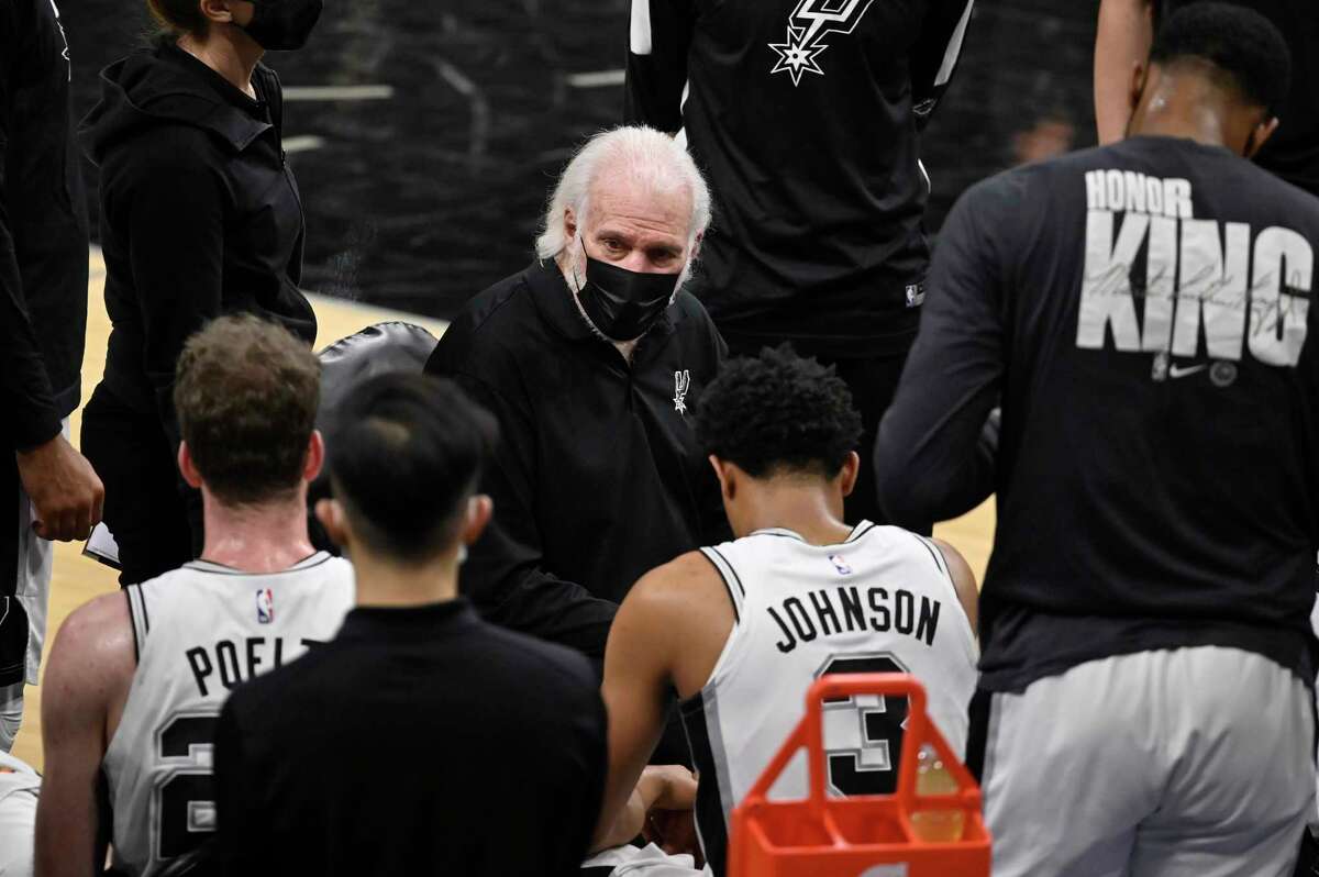 San Antonio Spurs head coach Gregg Popovich, center, talks to his players during a time out in the first half of an NBA basketball game against the Washington Wizards, Sunday, Jan. 24, 2021, in San Antonio. San Antonio won 121-101. (AP Photo/Darren Abate)
