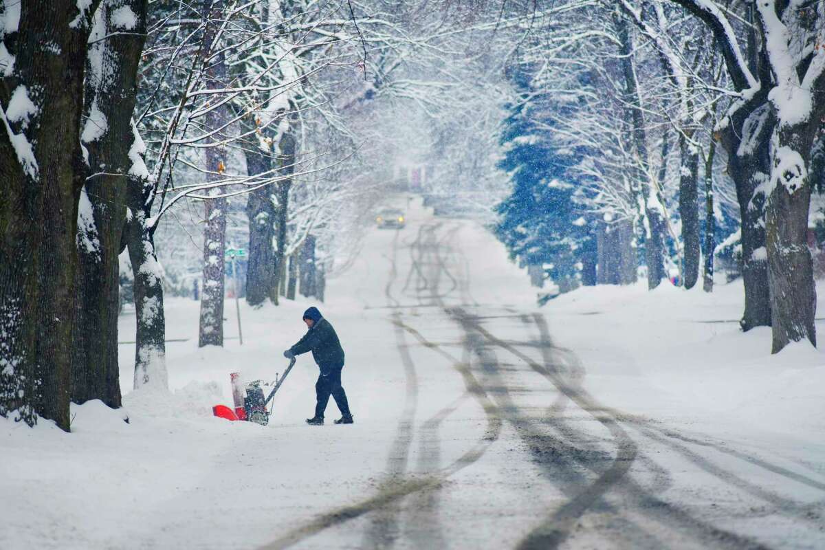 A man uses a snowblower to clear snow off a driveway on Wednesday, Jan. 27, 2021, in East Greenbush, N.Y. (Paul Buckowski/Times Union)