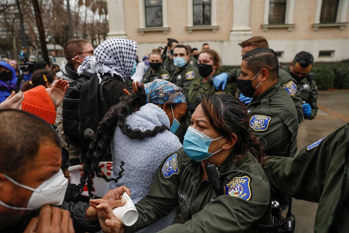 Sheriffs get in a skirmish as they push demonstrators to the sidewalk during a protest outside the Santa Clara County Courthouse in San Jose where protesters attempted to halt eviction proceedings from taking place on Wednesday, Jan. 27, 2021 in San Jose, California.