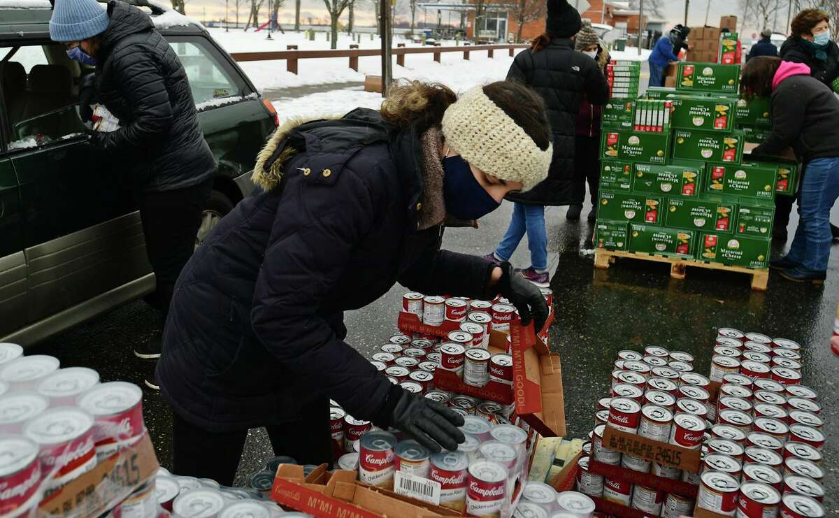 Local residents receive food distributed by volunteers with the CT Food Bank includig Koula Von Hoppe Wednesday, January 27, 2021, in Norwalk, Conn. Distribution events are held Wednesdays at Calf Pasture Beach from 9am to noon.