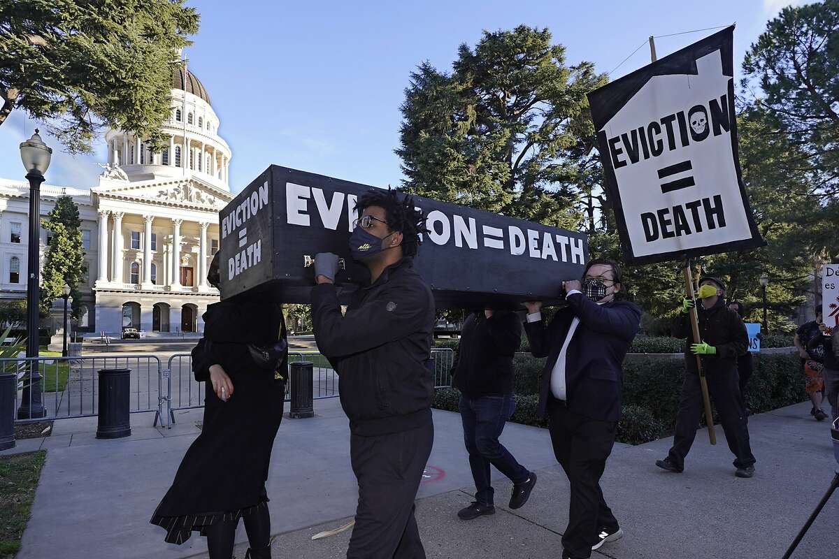 Demonstrators calling for lawmakers and Gov. Gavin Newsom to pass rent forgiveness and stronger eviction protections legislation carry a mock casket past the Capitol in Sacramento on Monday.