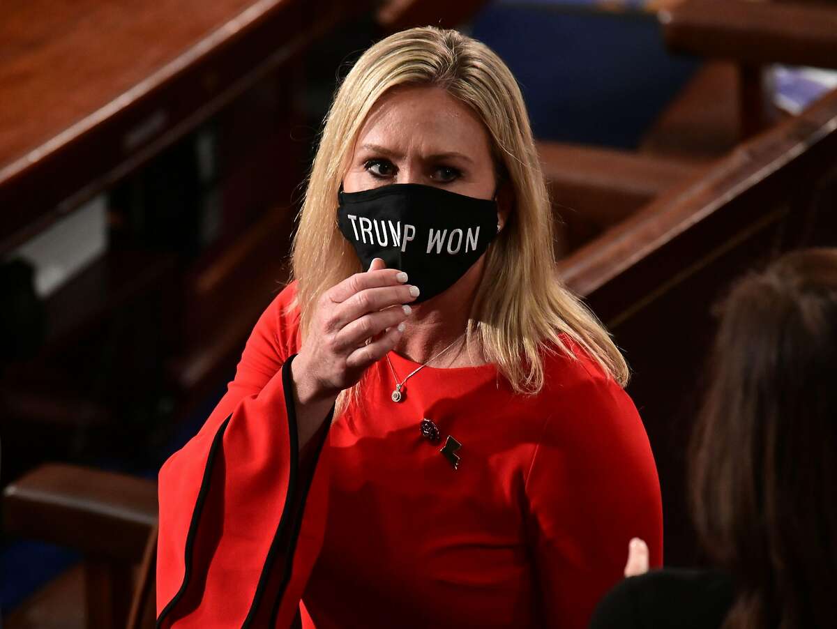 Rep. Marjorie Taylor Greene, R-Ga., wears a “Trump Won” face mask as she arrives on the floor of the House to take her oath of office on Jan. 3.