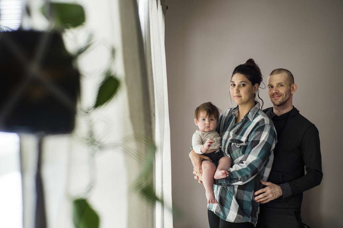 Natasha Maxwell, center, and Rob Maxwell, right, pose for a portrait with their daughter, Kaelyn, 6 months, left, Thursday, Jan. 28, 2021 at their home in Midland. Rob was recently diagnosed with a rare type of cancer called choriocarcinoma. (Katy Kildee/kkildee@mdn.net)