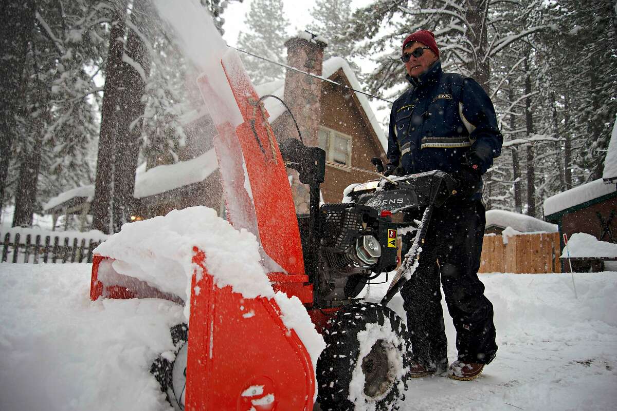 Mark Winberg plows a neighbor's driveway on Thursday in South Lake Tahoe after a storm that saw snow accumulate over a foot in under 24 hours.