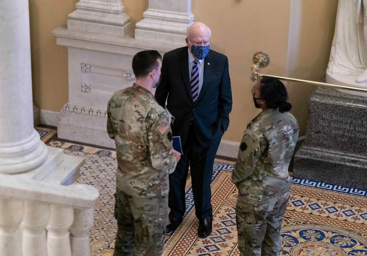 Sen. Patrick Leahy, D-Vt., the president pro tempore of the Senate, pauses to greet two members of the Pennsylvania National Guard at the Capitol in Washington on Tuesday.