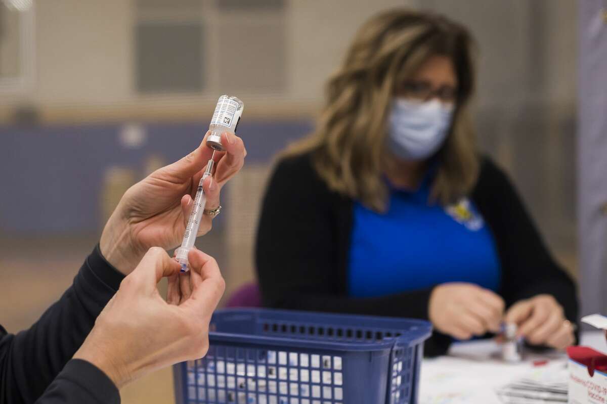 FILE — Local teachers and other school staff receive the Moderna COVID-19 vaccine during a vaccination clinic on Jan. 29, 2021 at the Midland County Educational Service Agency building.