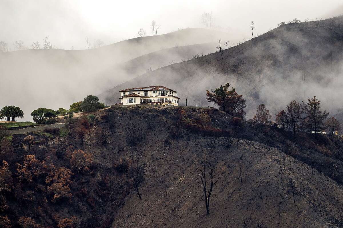 A home sits atop a hillside scorched by last year's River Fire as heavy rains caused mudslides and flooding near Salinas on Thursday.