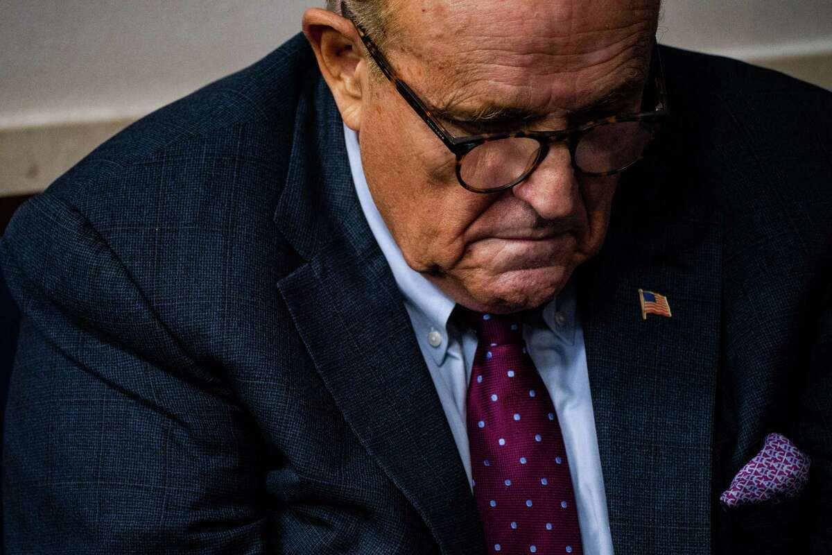 Rudy Giuliani listens as then-President Trump held a news briefing at the White House on Sept. 27, 2020.