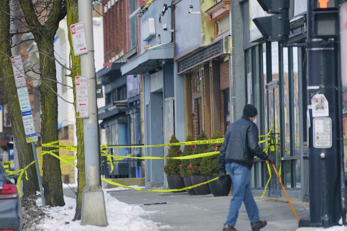 Police tape blocks off a section of the sidewalk at the scene near 211 Central Ave. in Albany, N.Y., where Albany Police said that three women and two men were shot late Saturday night. One woman died. (Paul Buckowski/Times Union)