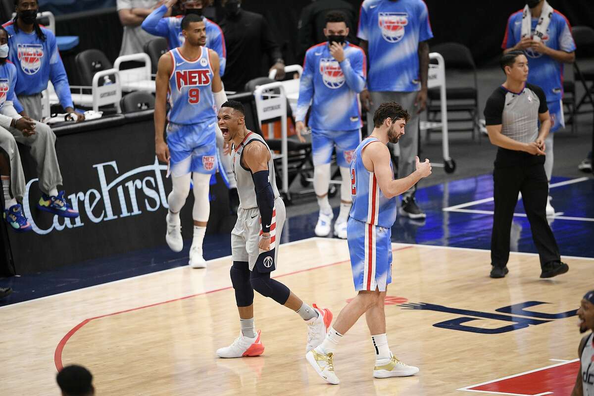 Washington Wizards guard Russell Westbrook (4) reacts next to Brooklyn Nets forward Joe Harris, right, after he made a there-point basket during the closing seconds of the second half of an NBA basketball game, Sunday, Jan. 31, 2021, in Washington. The Wizards won 149-146. (AP Photo/Nick Wass)