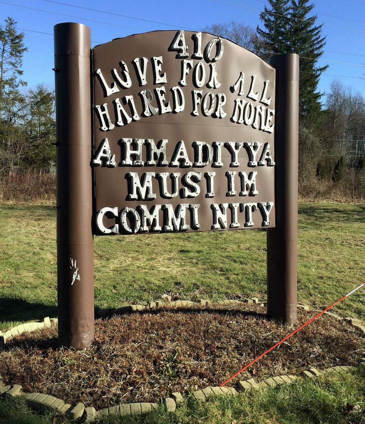 A sign inscribed “Love for all, hatred for none” stands outside the Baitul Aman mosque where the Ahmadiyya Muslim Community worships in Meriden.