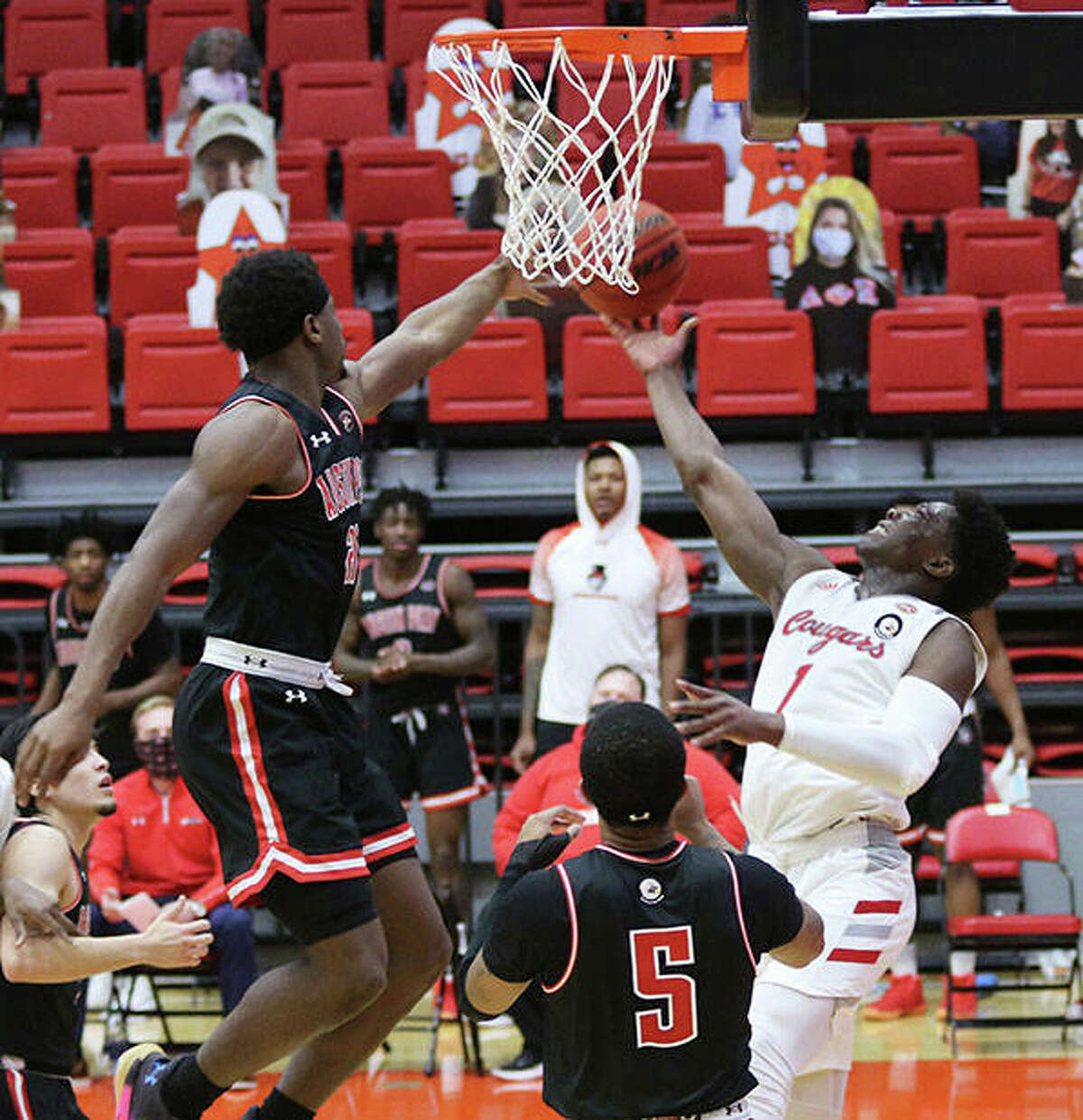 SIUE’s Mike Adewunmi (1) extends to get a shot off over Austin Peay’s Terry Taylor (left) while Jordyn Adams (5) watches the play Monday in Edwardsville.