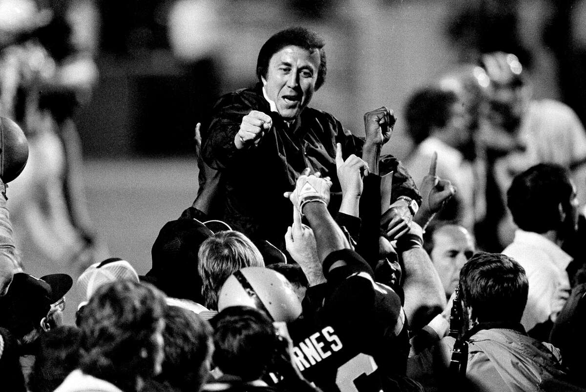Los Angeles Raiders Coach Tom Flores gestures to members of the as they carry him off the field after their 38-9 victory over the Washington Redskins in Super Bowl XVIII in Tampa, Florida, on Jan. 23, 1984.