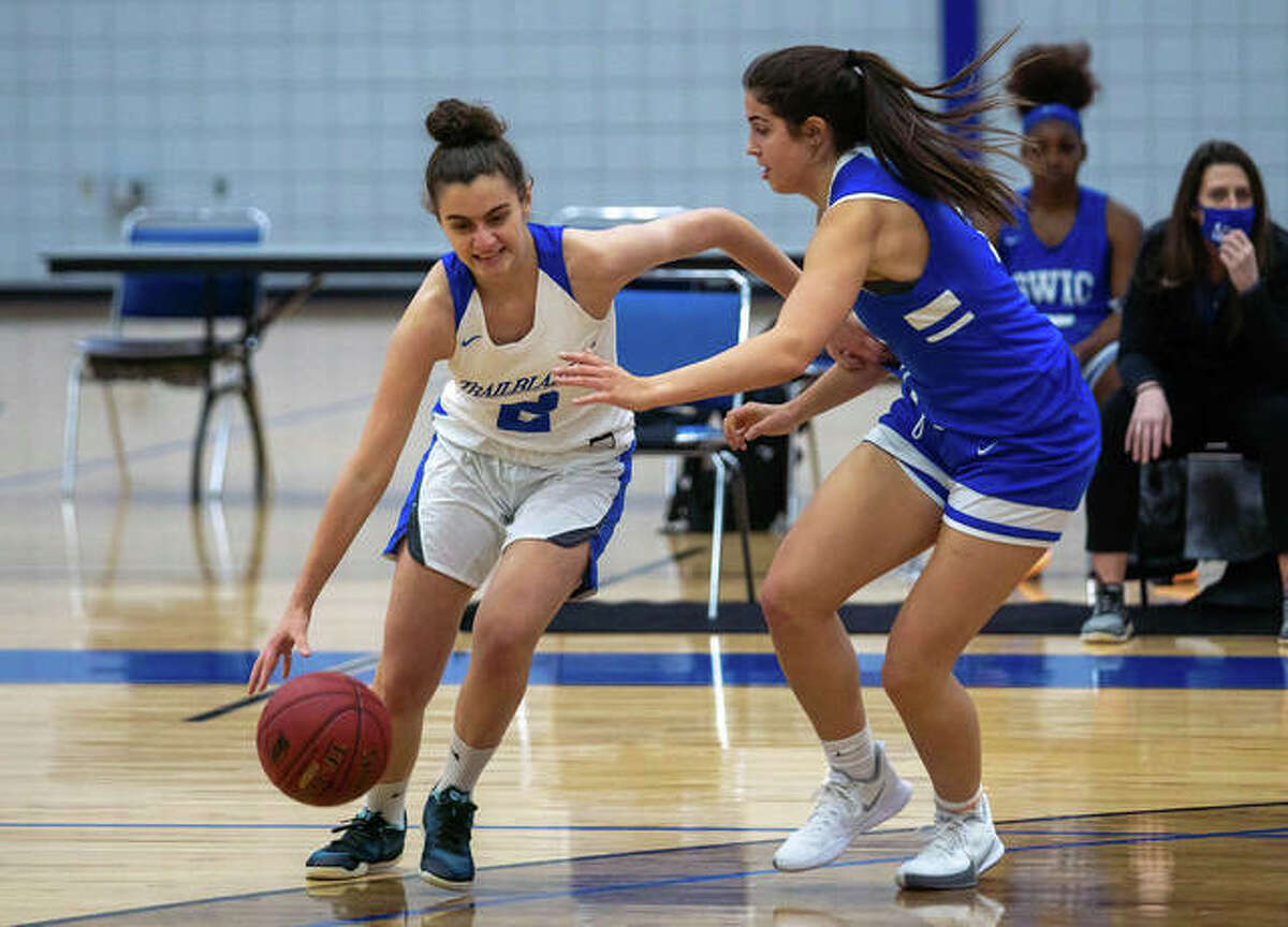 Lewis and Clark’s Judith Girones (2), from Barcelona, Spain, drives around SWIC’s Keiarra Cotton (23) Monday in the LCCC season opener in Godfrey.