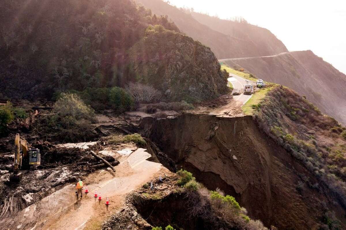 Construction crews work on a section of Highway 1 which collapsed into the Pacific Ocean near Big Sur, California on January 31, 2021. - Heavy rains caused debris flows of trees, boulders and mud that washed out a 150-foot section of the road.